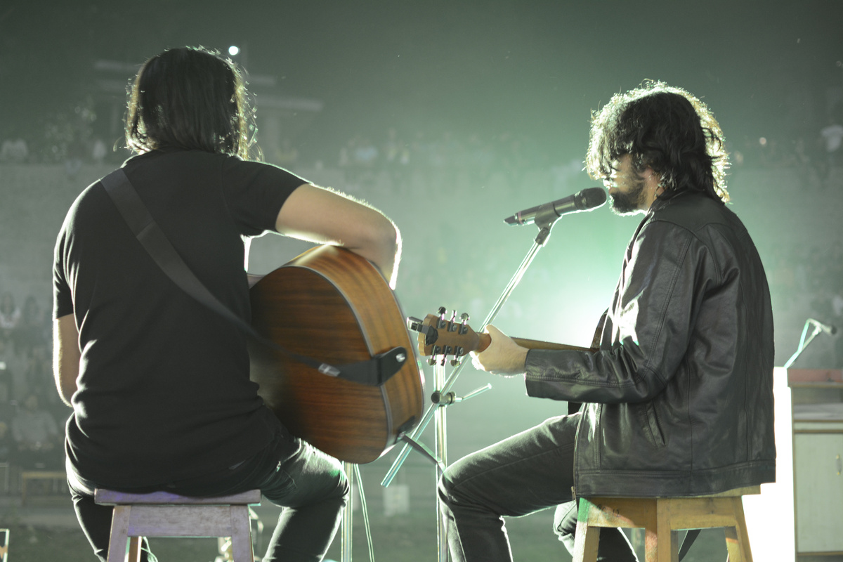 Male musicians with guitars performing on concert